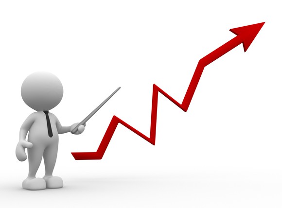 A cartoon figure pointing towards an upward trending graph.