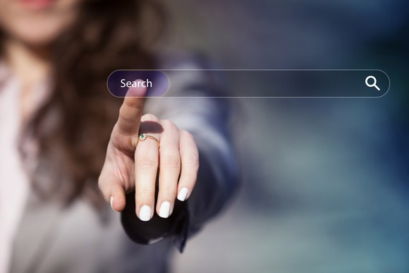 A woman touches her finger to the word "Search" on a transparent internet search bar.