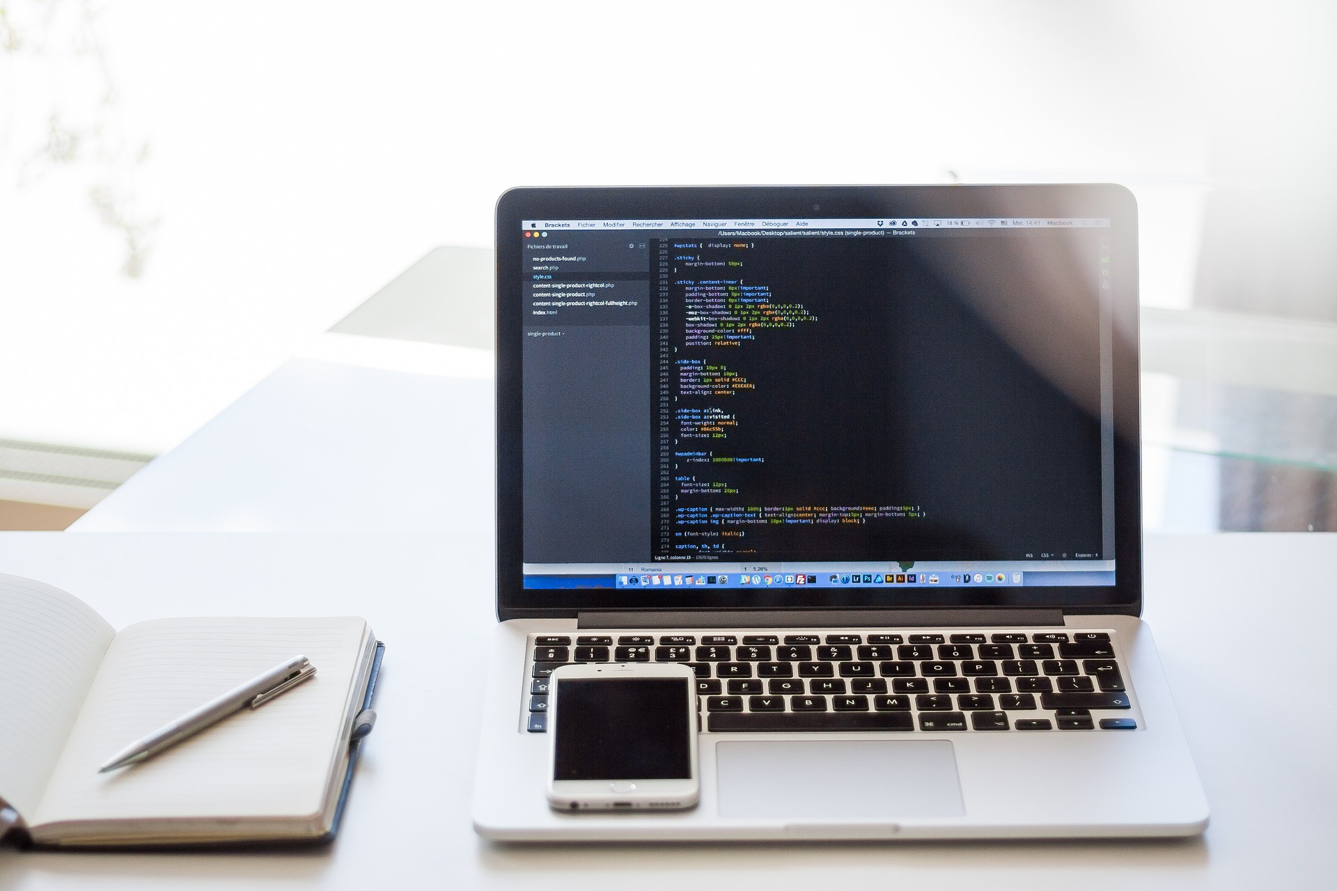 A smartphone and a laptop with code on the screen.
