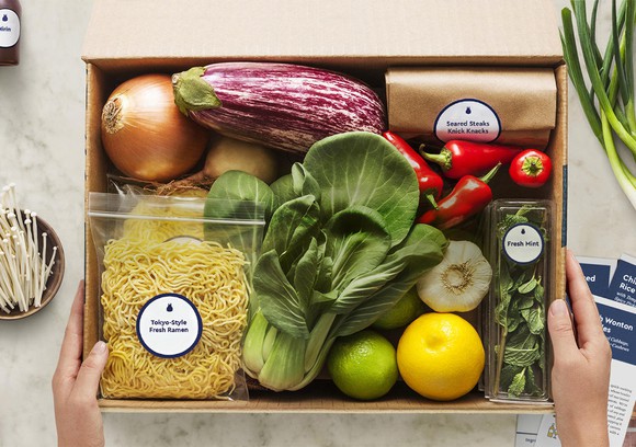 A Blue Apron box containing ingredients for a meal.