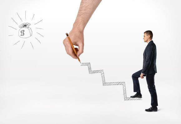 Man with drawing of steps leading to bag of money