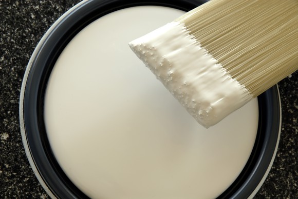 Can and brush with white paint