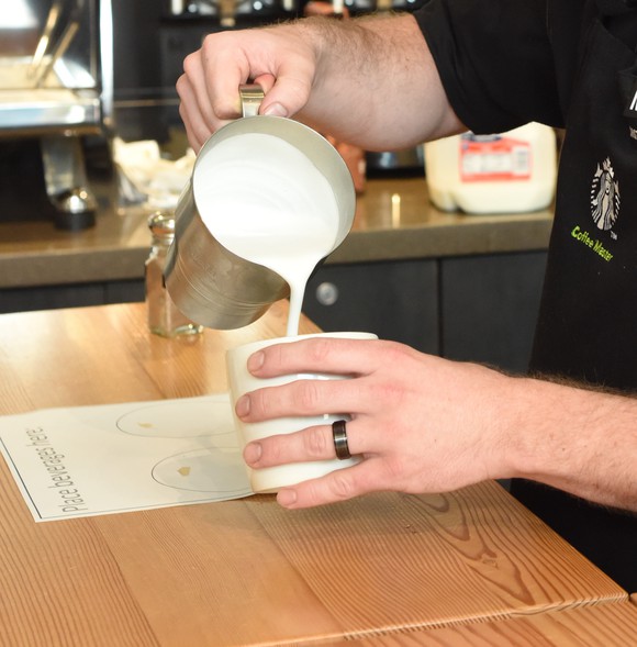 A Starbucks barista pouts a drink