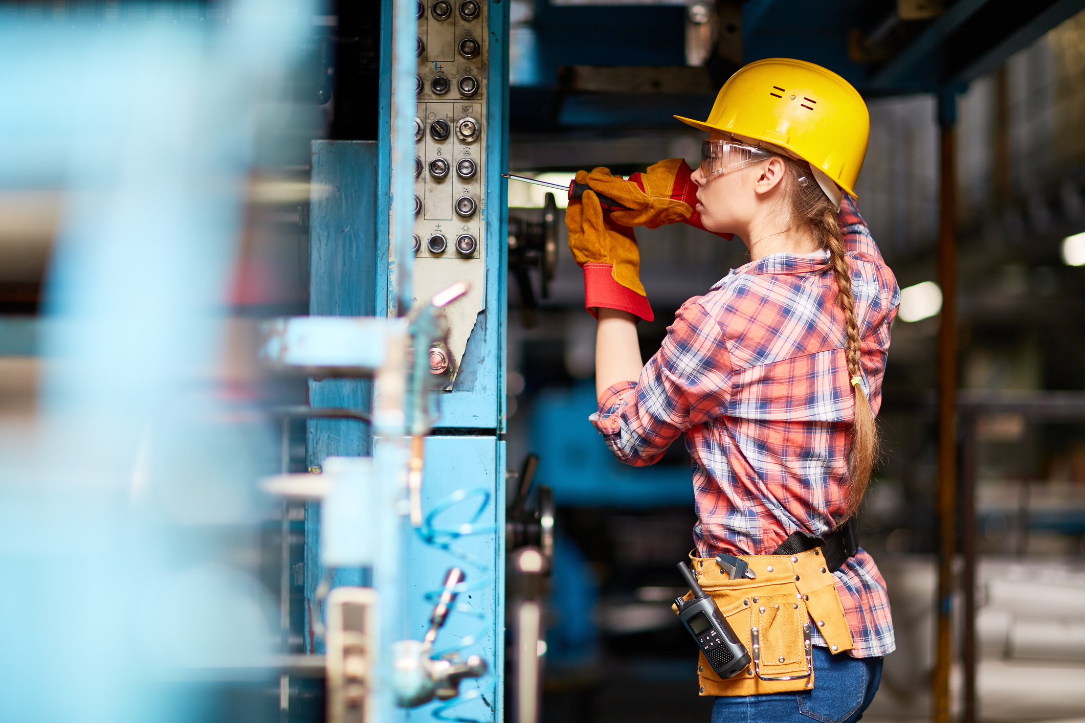 A maintenance worker fixes a machine