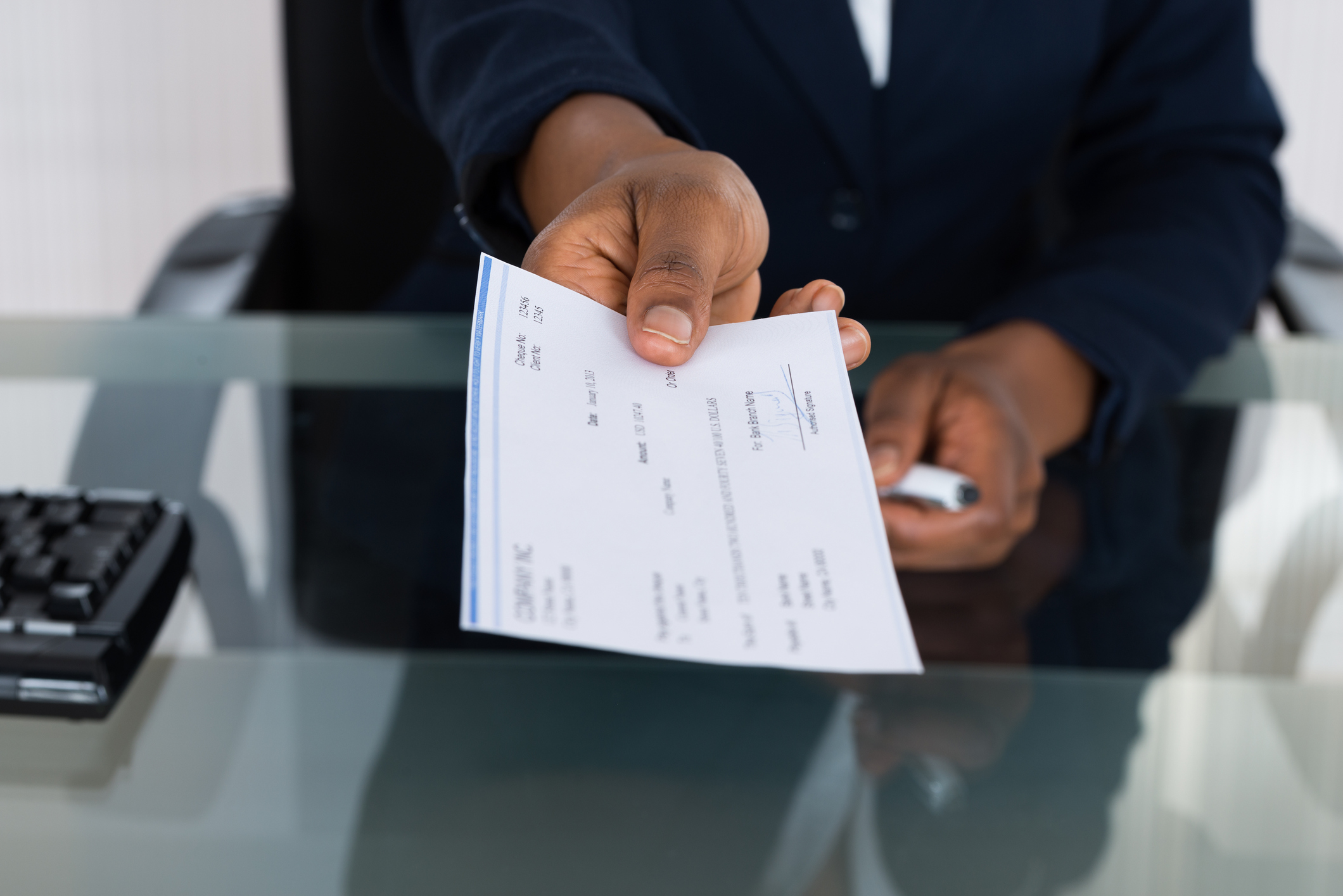 Man handing paycheck.