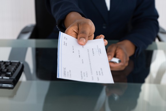 Man handing paycheck.