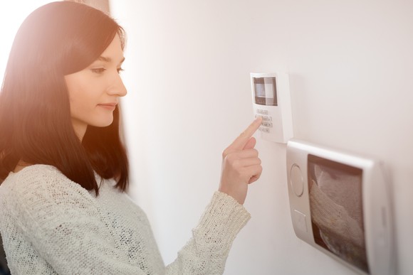 Woman entering a code on home security panel