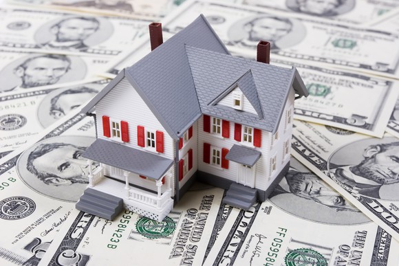 Pile of bills with model house