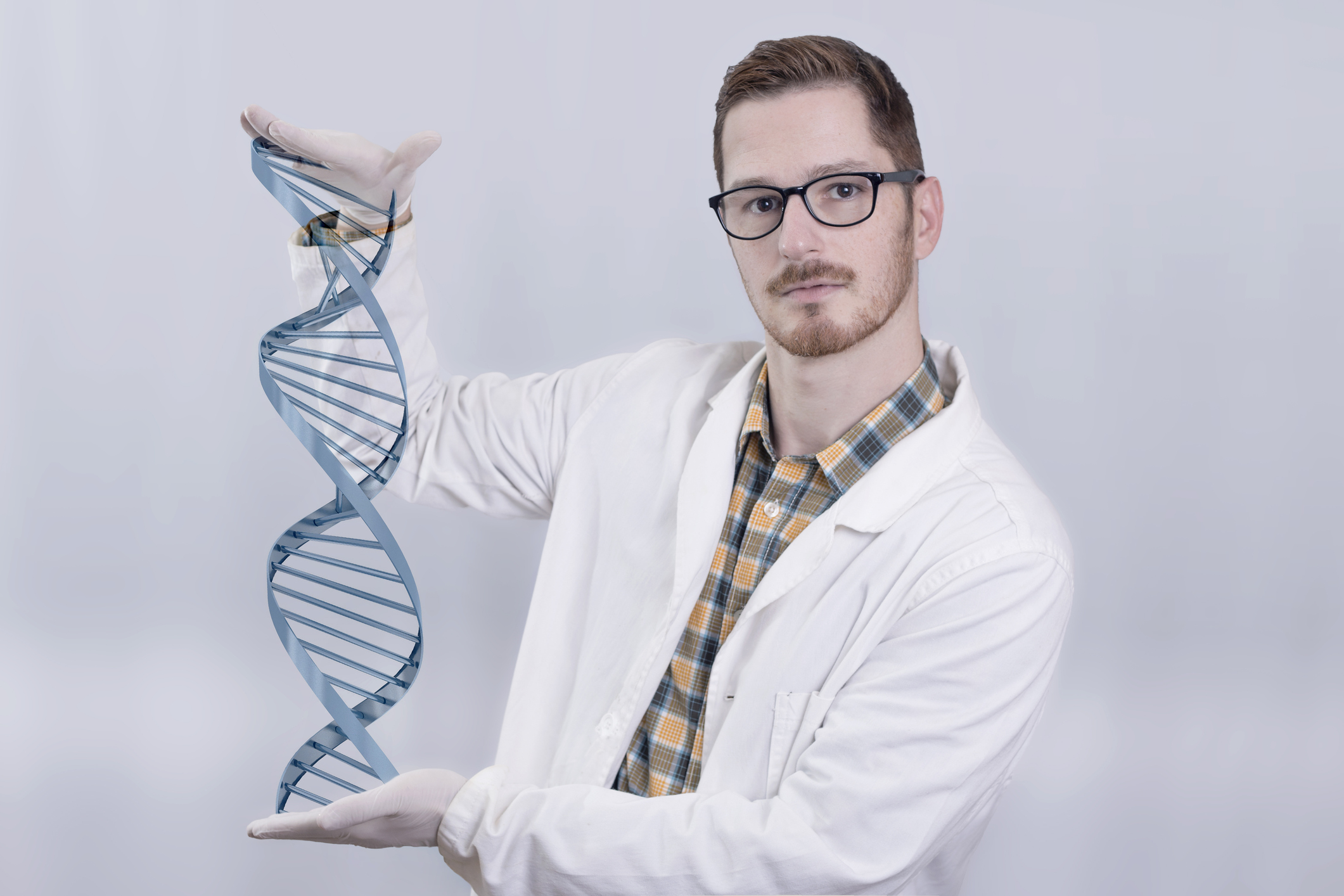 A biotech lab researcher holding a DNA double-helix model.