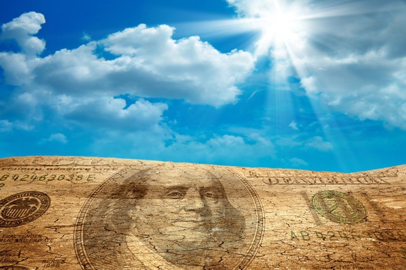 The summer sun beating down on a hillside in the image of a hundred dollar bill.