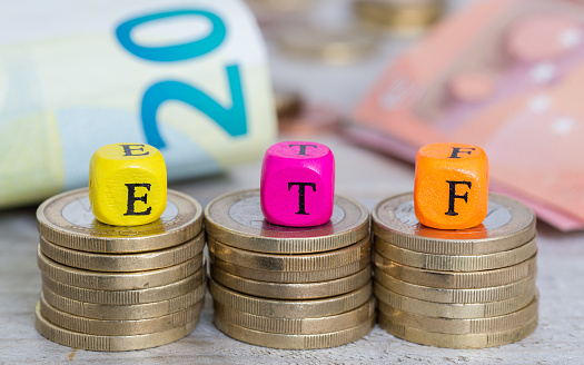 Photo of stacked coins with ETF dice perched on top of each.