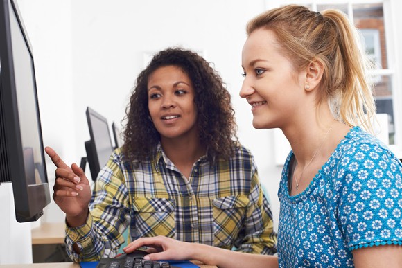 Two women in front of a computer monitor