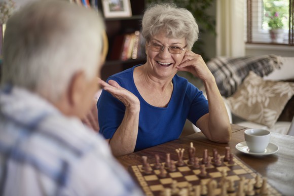 Retired couple playing chess.