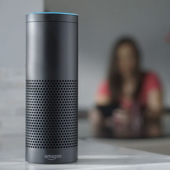 Amazon Echo with blurry image of woman in the background.