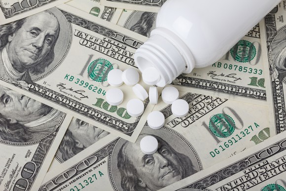 Pills on a pile of money.