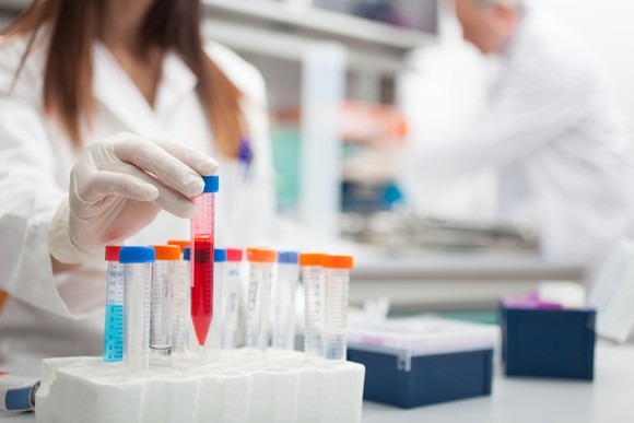 A scientist working with vials in a lab.