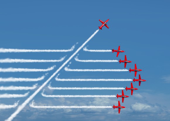 Seven planes flying in formation, with an eighth plane breaking away