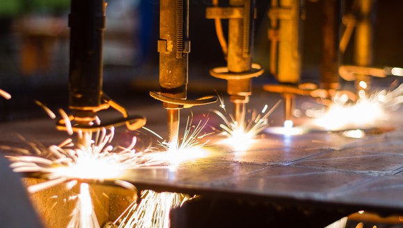 5 laser cutters slicing through some sheet metal.