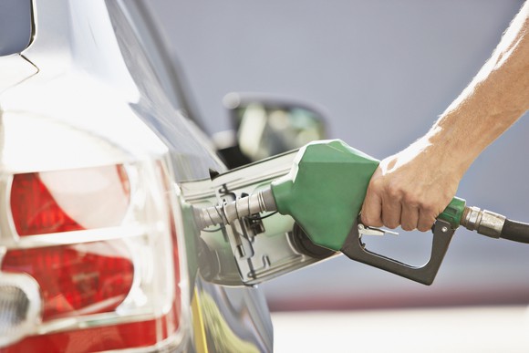 A person pumps gas.