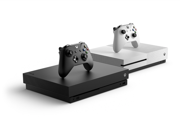 Two Xbox One X consoles, one white and one black, side by side against white background.