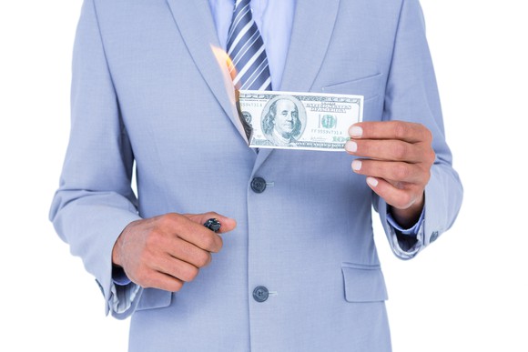 business man setting fire to money