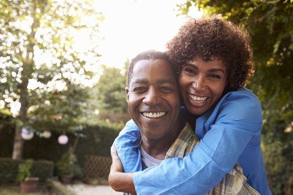 Mature couple hugging and smiling in backyard