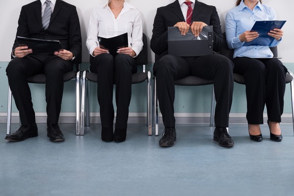Close-up Of Businesspeople With Files Sitting On Chairs