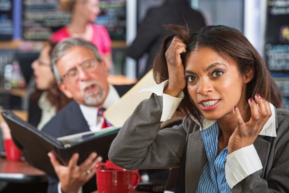 A woman pulls her hair out in annoyance at her co-worker.