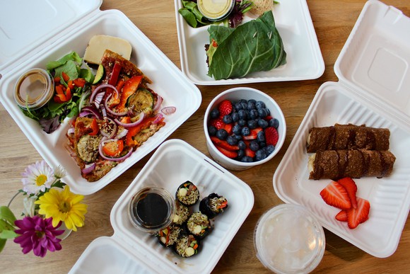 Fresh food in takeout containers laid out on a table