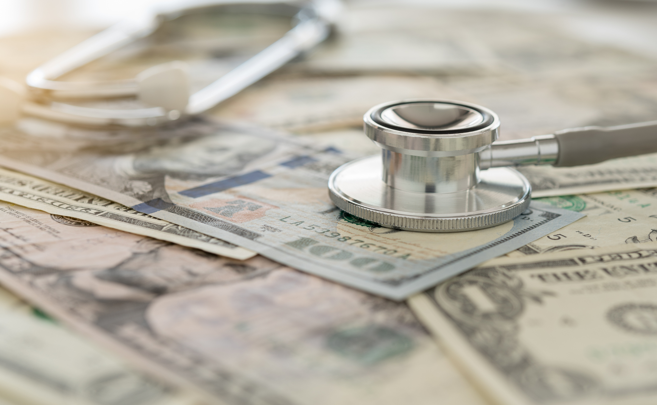 Pile of money with stethoscope.