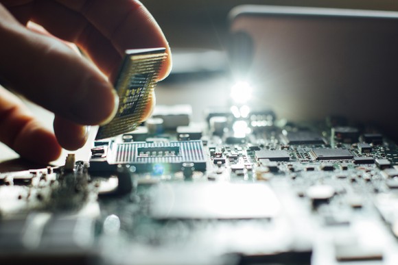 A man installs a CPU on a motherboard.