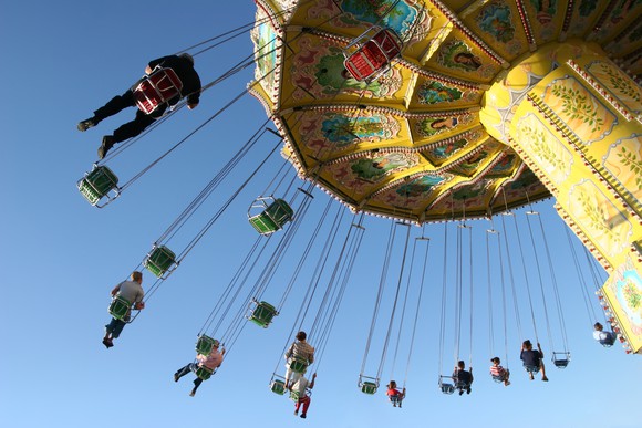 People riding on carousel swing high in air.