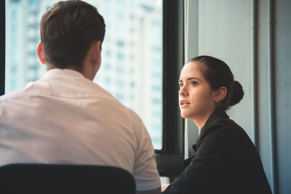A businesswoman and man sit together.