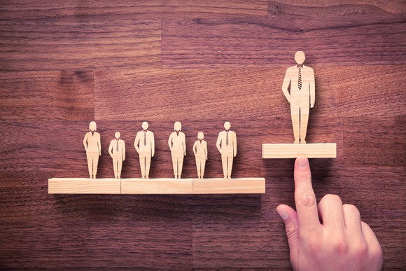 Wooden figures representing a boss and workers.