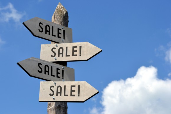 Four "Sale!" signs pointing in different directions.