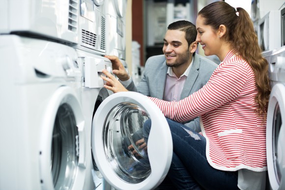 A woman and man look at washing machines