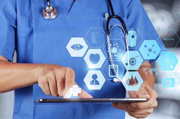 Doctor with tablet and medical icons.