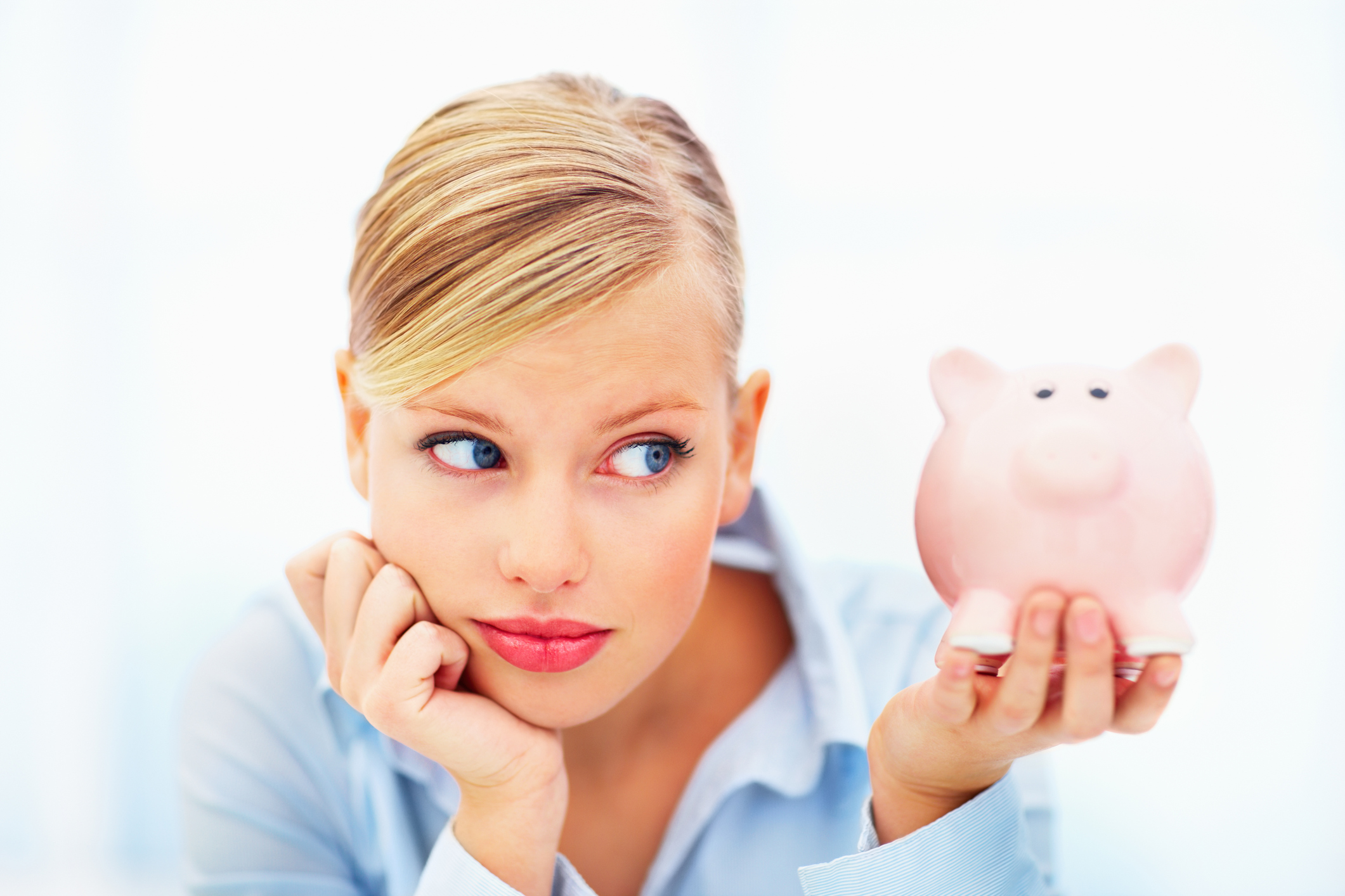 A millennial looking at her piggy bank.