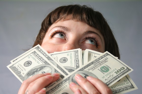 Young woman holding a stack of $100 bills