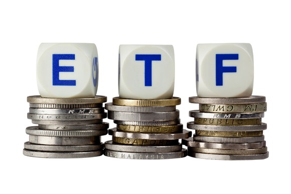 Three dice spelling "ETF" on top of stacks of coins