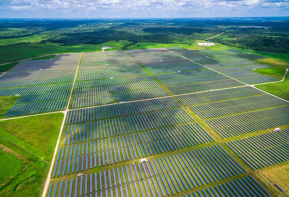 An aerial view of large solar farm in grassy area.