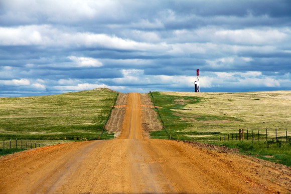 An oil rig down a dirt road in the Bakken.
