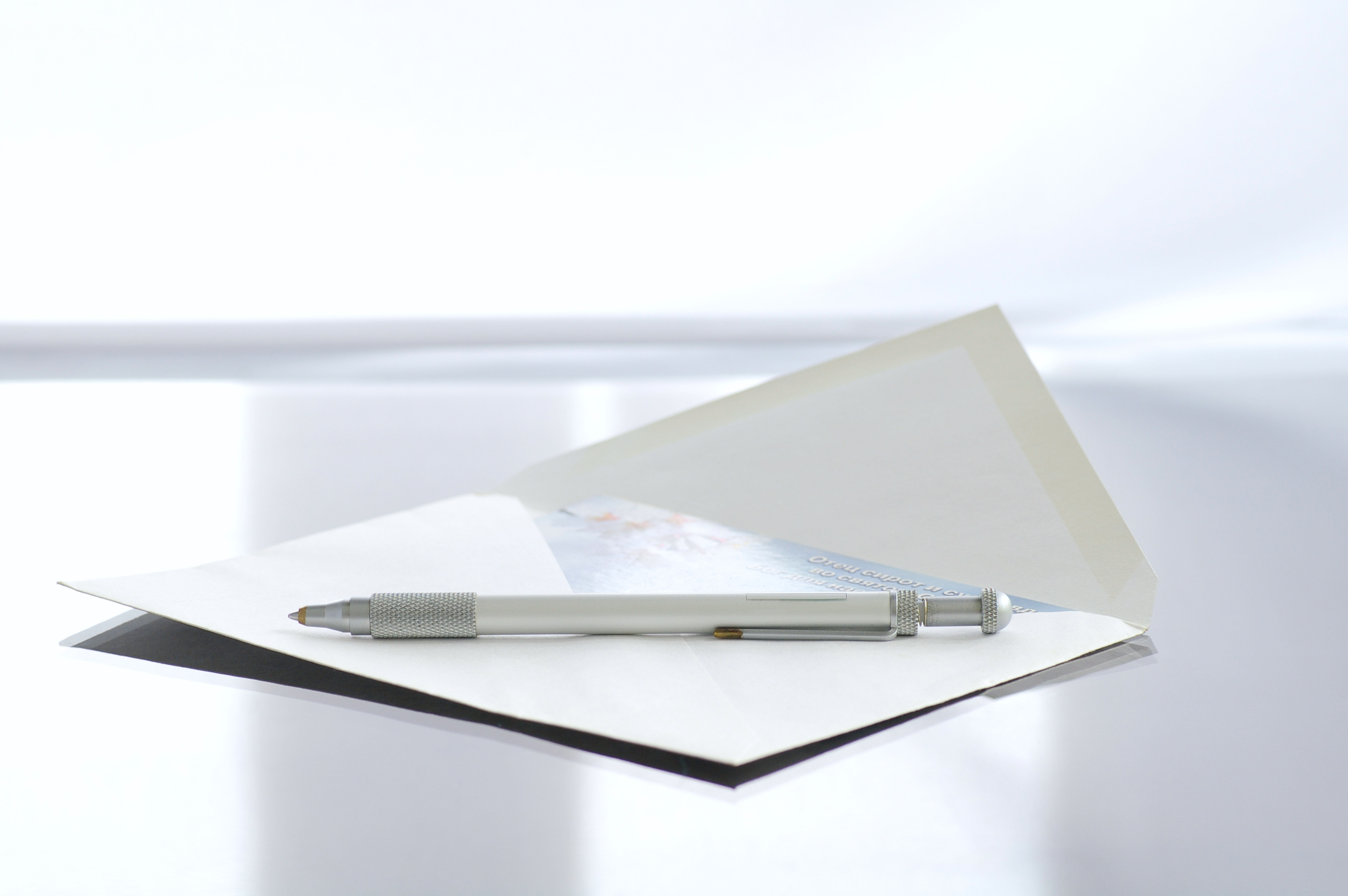 A note cars sits in an envelope with a pent on top of it