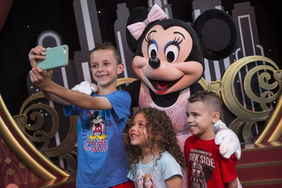 Minnie Mouse taking photos with kids at Disney World.