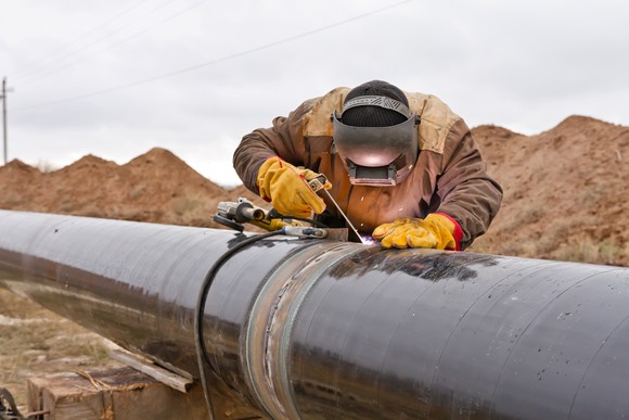 A man welding a pipeline.