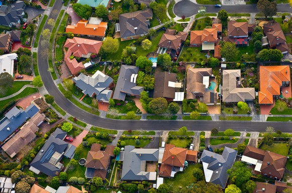 Aerial shot of a densely packed neighborhood along a winding road