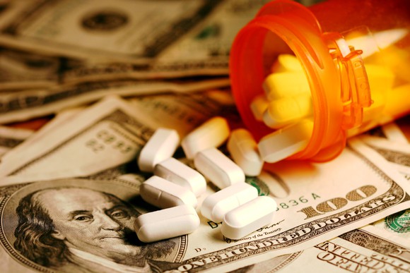 A bottle of prescription drugs spilling on money.