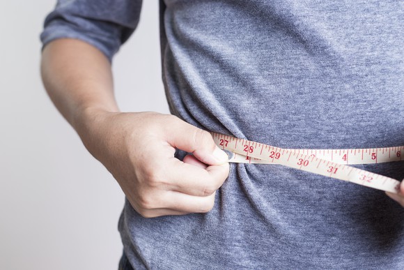 Person checking their waistline.