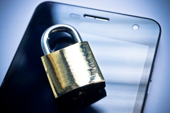 Locked padlock on top of a smartphone.