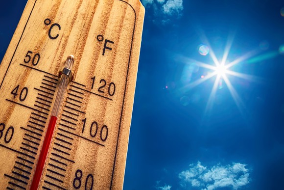 A wooden thermometer in the sun on a hot day.